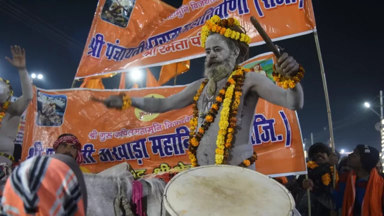 Image of a naga sadhu playing drums in panchayati akhara jhanki during kumbh mela